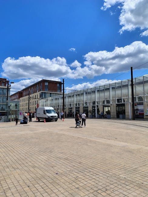 The image shows Bermondsey train station platform with a covered iron and glass canopy overhead, supported by metal beams and trusses. The platform surface is paved with concrete, featuring tactile pa